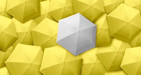 Image of White umbrella among yellow ones, top view. Banner design