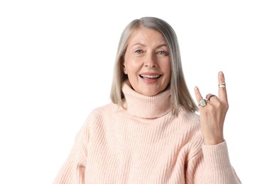 Photo of Senior woman wearing different rings and making rock gesture on white background