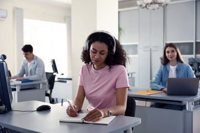 Photo of People working at desks in library, selective focus