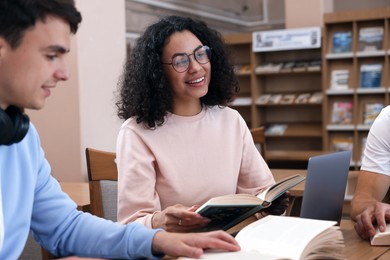 Photo of People studying together at desk in public library