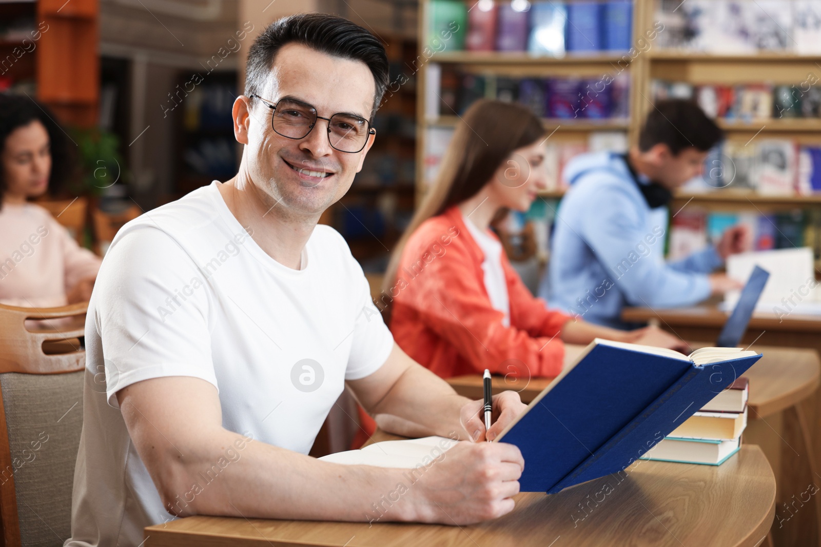 People studying at desks in public library, selective focus Photo of People studying at desks in public library, selective focus