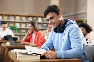 Photo of People studying at desks in public library, selective focus