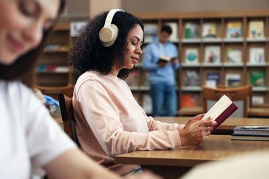 Photo of People studying in public library, selective focus