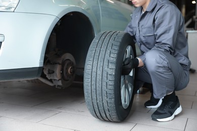 Photo of Mechanic changing tire at car service, closeup