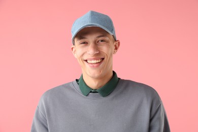 Photo of Young man in stylish baseball hat on pink background