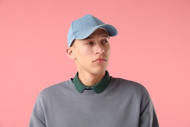 Photo of Young man in stylish baseball hat on pink background