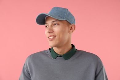 Photo of Young man in stylish baseball hat on pink background