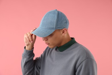 Photo of Young man in stylish baseball hat on pink background