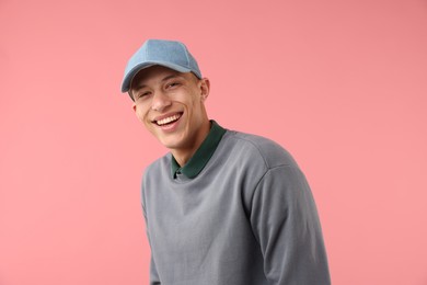 Photo of Young man in stylish baseball hat on pink background