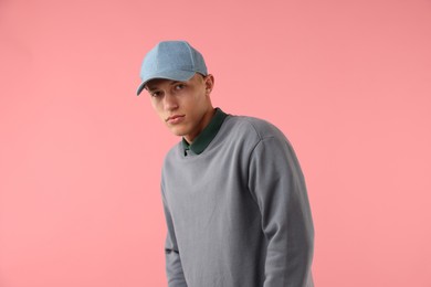 Photo of Young man in stylish baseball hat on pink background