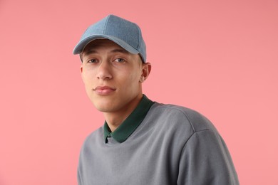Photo of Young man in stylish baseball hat on pink background