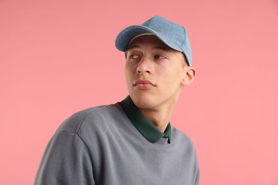 Photo of Young man in stylish baseball hat on pink background