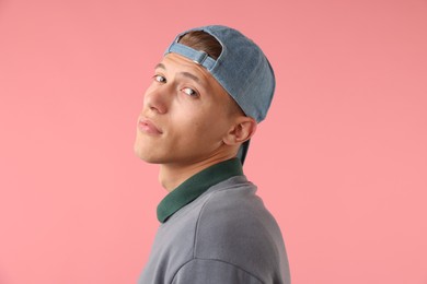 Photo of Young man in stylish baseball hat on pink background