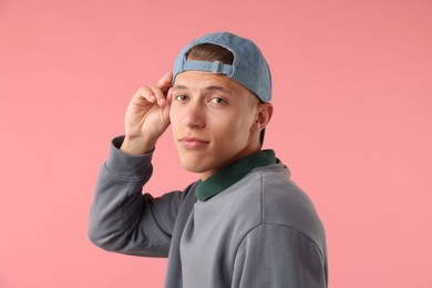 Photo of Young man in stylish baseball hat on pink background