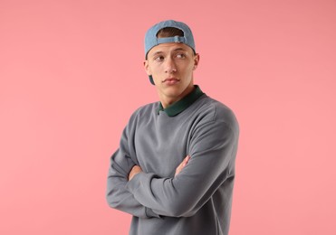 Photo of Young man in stylish baseball hat on pink background