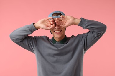 Photo of Young man in stylish baseball hat on pink background