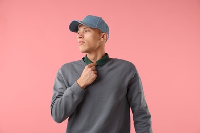 Photo of Young man in stylish baseball hat on pink background