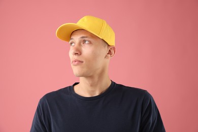 Photo of Young man in stylish baseball hat on pink background