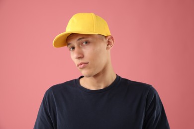 Photo of Young man in stylish baseball hat on pink background