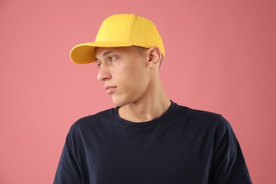 Photo of Young man in stylish baseball hat on pink background