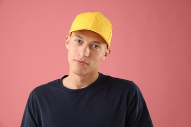 Photo of Young man in stylish baseball hat on pink background