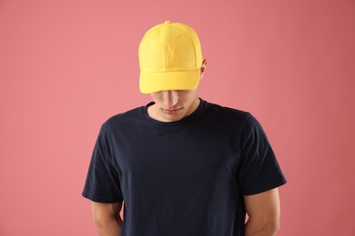 Photo of Young man in stylish baseball hat on pink background