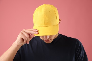 Photo of Young man in stylish baseball hat on pink background