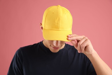 Photo of Young man in stylish baseball hat on pink background