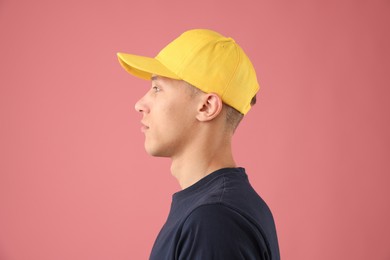 Photo of Young man in stylish baseball hat on pink background
