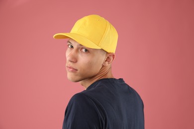 Photo of Young man in stylish baseball hat on pink background