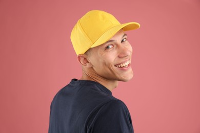 Photo of Young man in stylish baseball hat on pink background