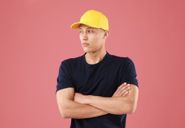 Photo of Young man in stylish baseball hat on pink background