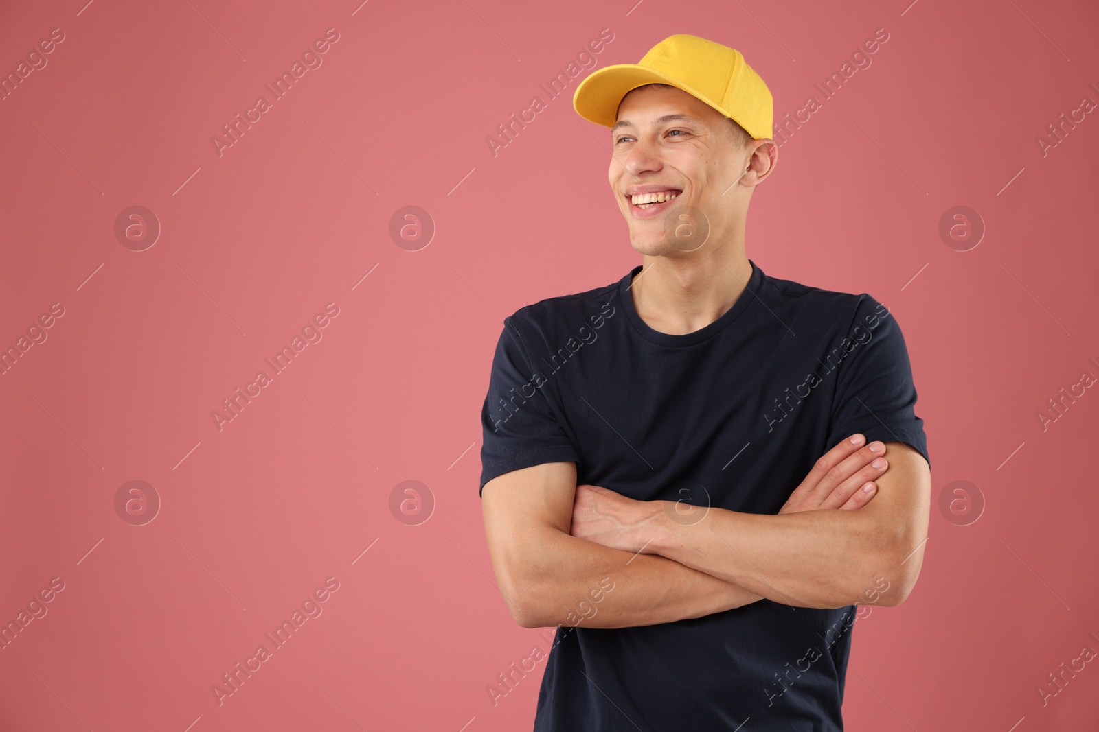Young man in stylish baseball hat on pink background, space for text Photo of Young man in stylish baseball hat on pink background, space for text