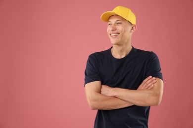 Photo of Young man in stylish baseball hat on pink background, space for text