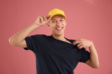 Photo of Young man in stylish baseball hat on pink background