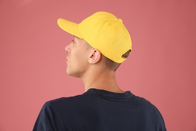 Photo of Young man in stylish baseball hat on pink background