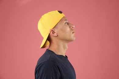 Photo of Young man in stylish baseball hat on pink background