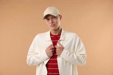 Photo of Young man in stylish baseball hat on beige background