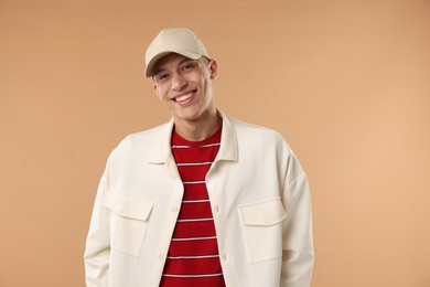 Photo of Young man in stylish baseball hat on beige background