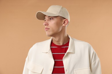 Photo of Young man in stylish baseball hat on beige background