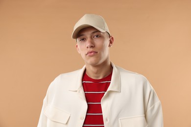 Photo of Young man in stylish baseball hat on beige background