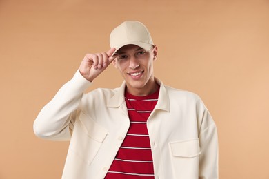 Photo of Young man in stylish baseball hat on beige background