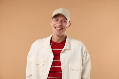 Photo of Young man in stylish baseball hat on beige background