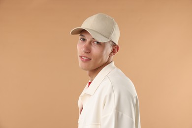 Photo of Young man in stylish baseball hat on beige background