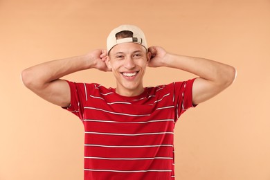 Photo of Young man in stylish baseball hat on beige background