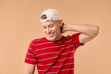 Photo of Young man in stylish baseball hat on beige background