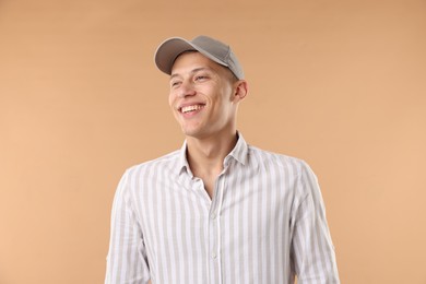 Photo of Young man in stylish baseball hat on beige background