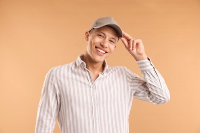 Photo of Young man in stylish baseball hat on beige background