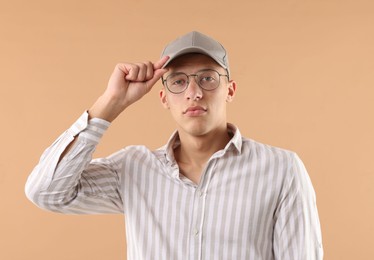Photo of Young man in stylish baseball hat on beige background
