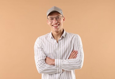 Photo of Young man in stylish baseball hat on beige background